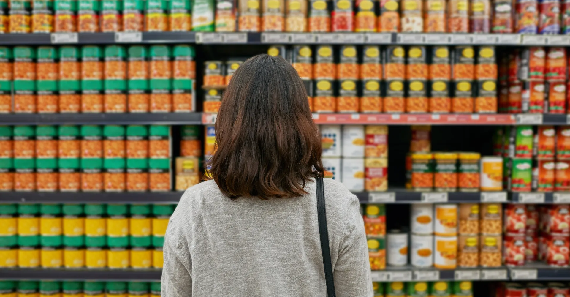 Eine Frau vor einem riesigen Supermarktregal