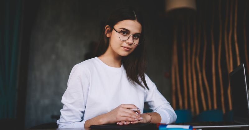 A young woman in the office working on a laptop.